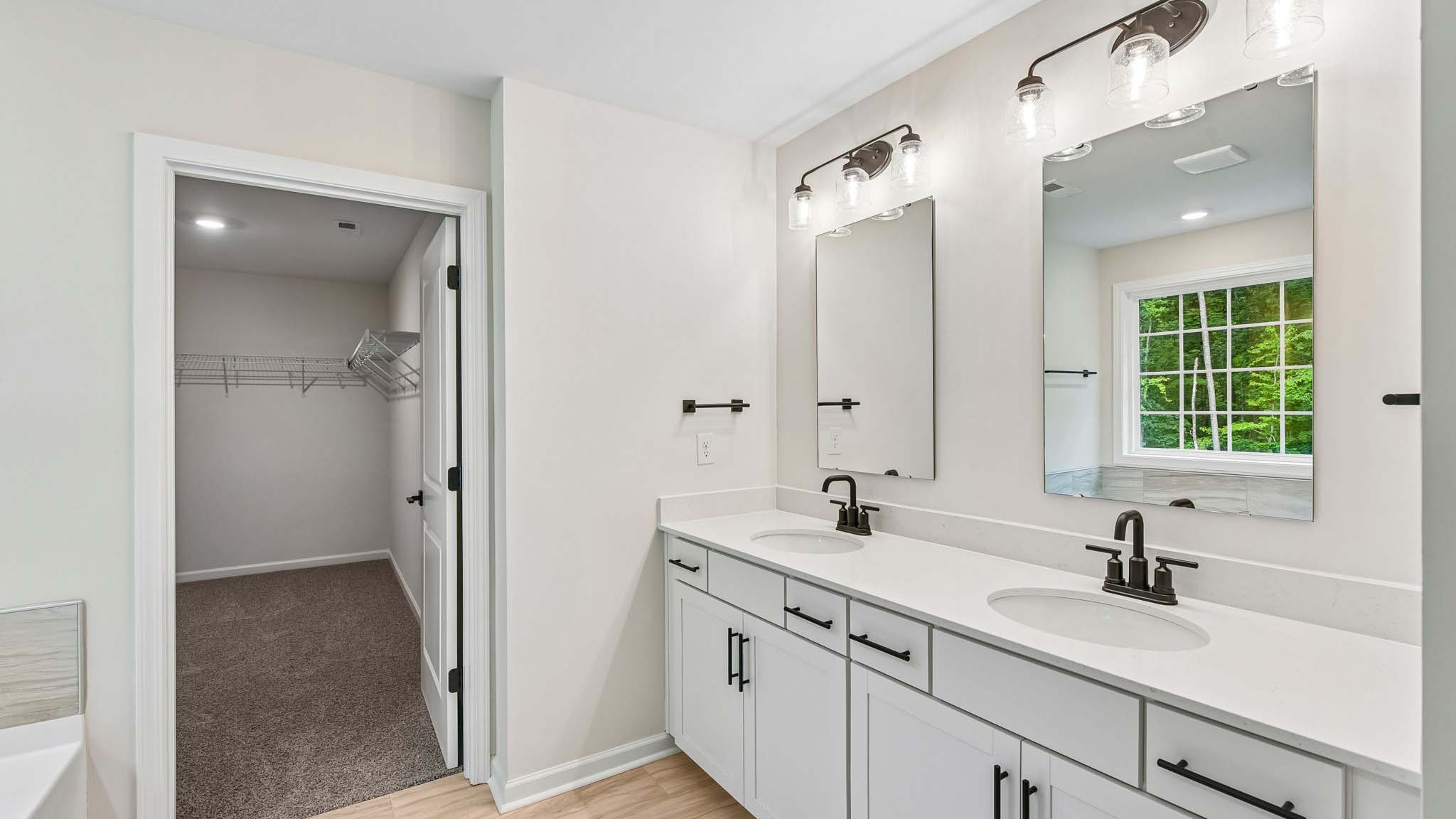 Primary bathroom with double sinks and standing glass shower
