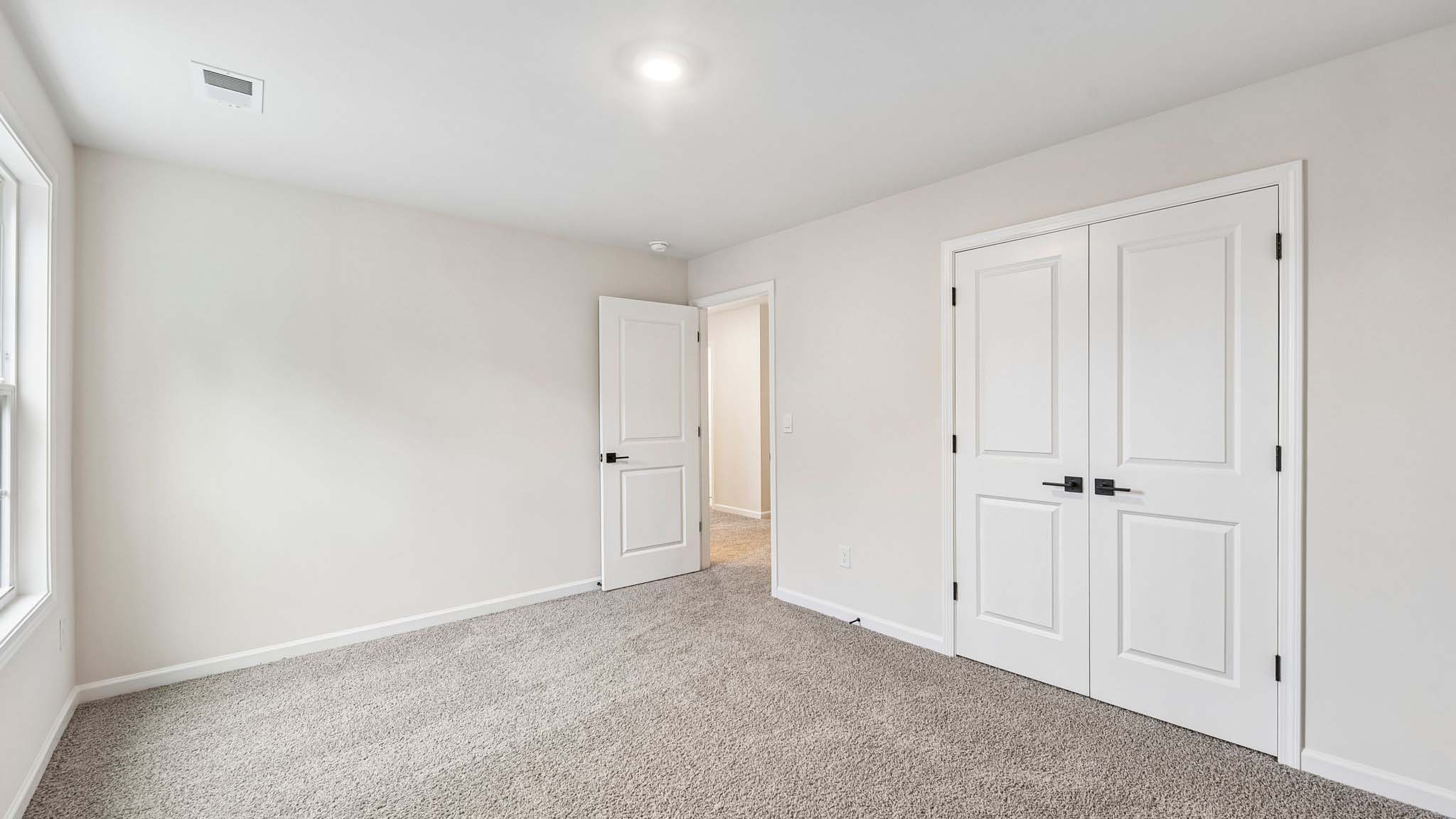 Carpeted bedroom with large window