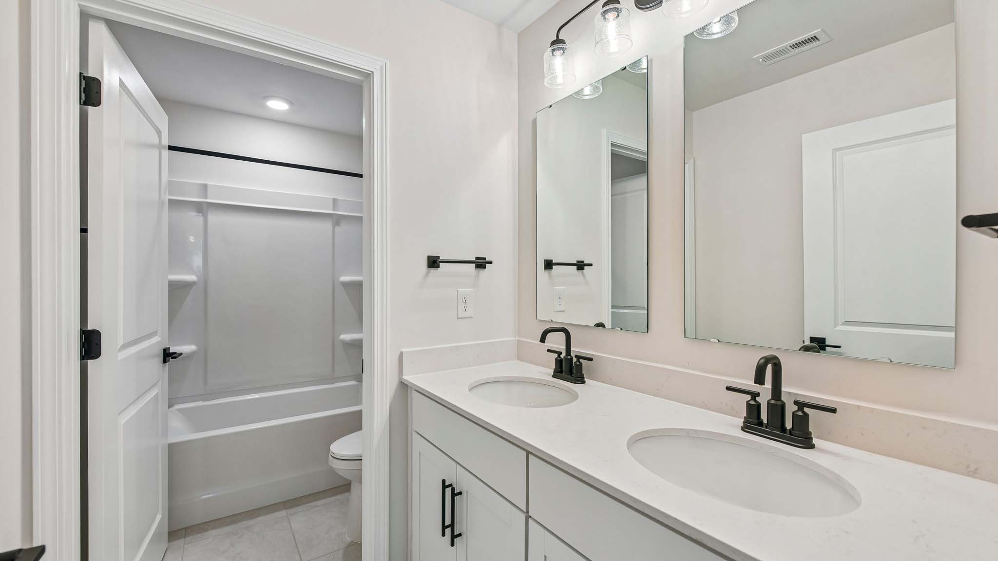 Bathroom with double sinks and tub shower combination