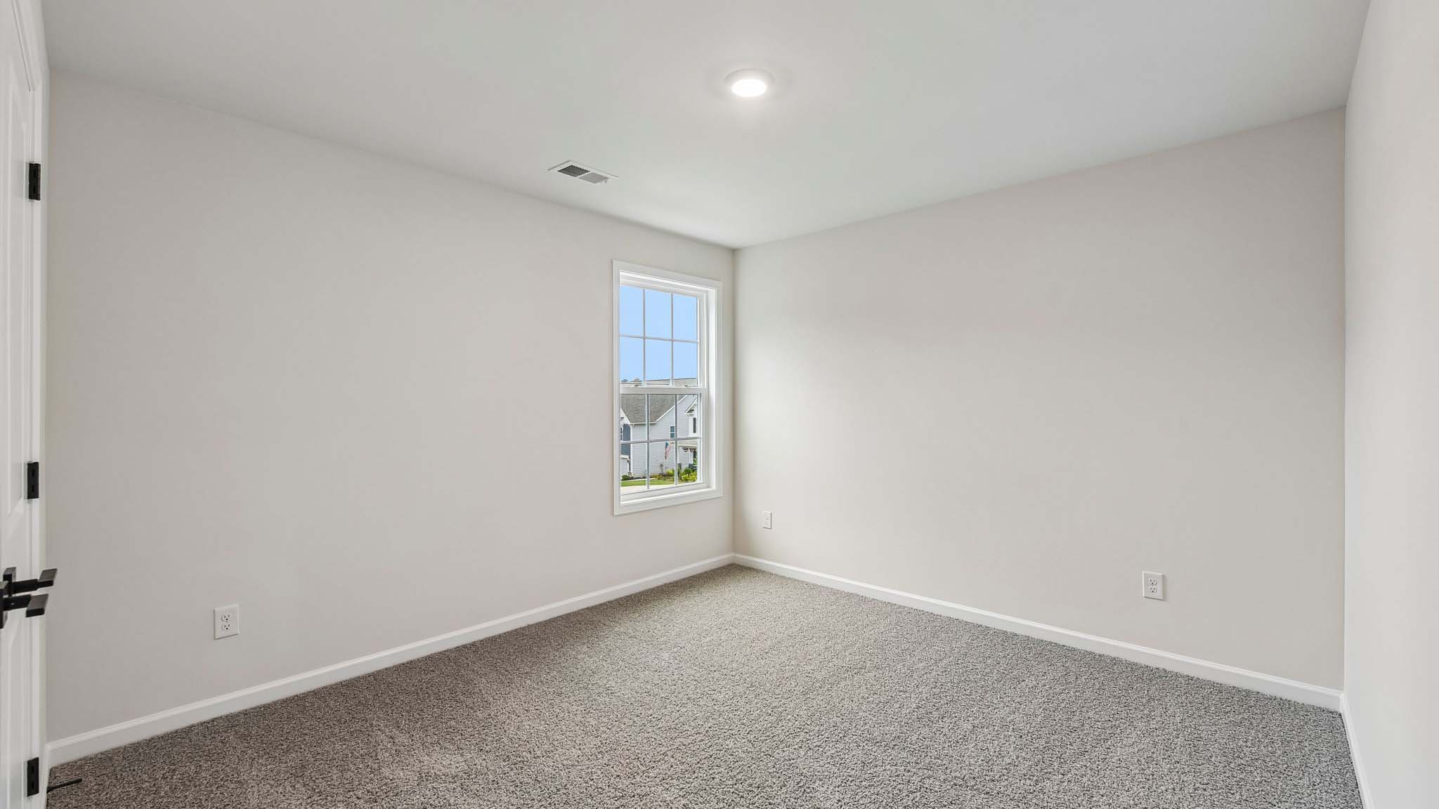 Carpeted bedroom with large window