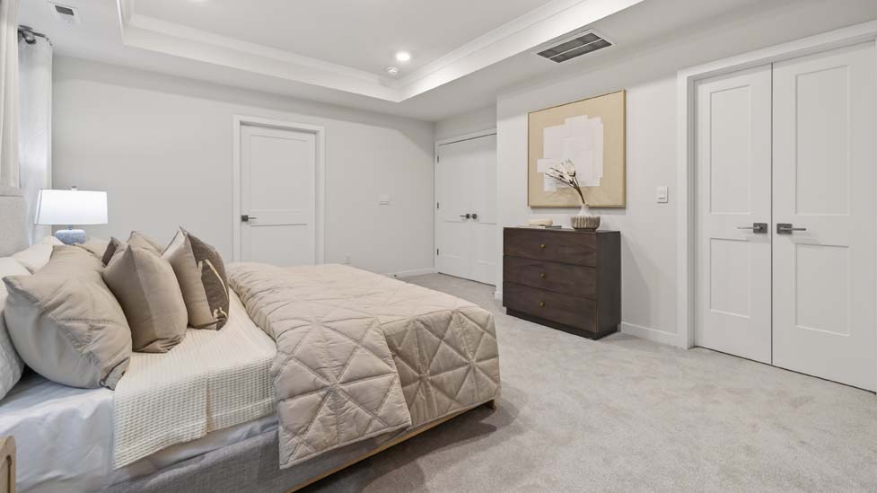 Carpeted primary bedroom with large windows