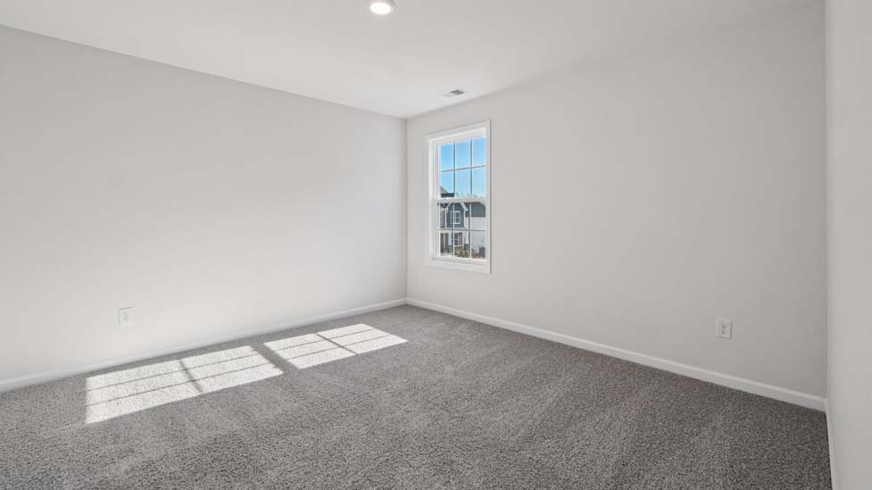 Carpeted bedroom with small window