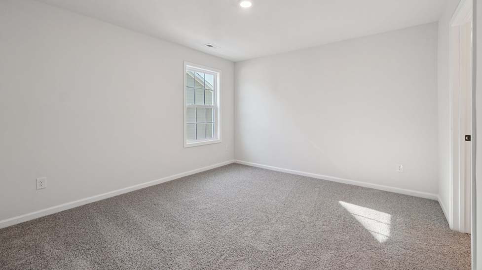 Carpeted bedroom with small window