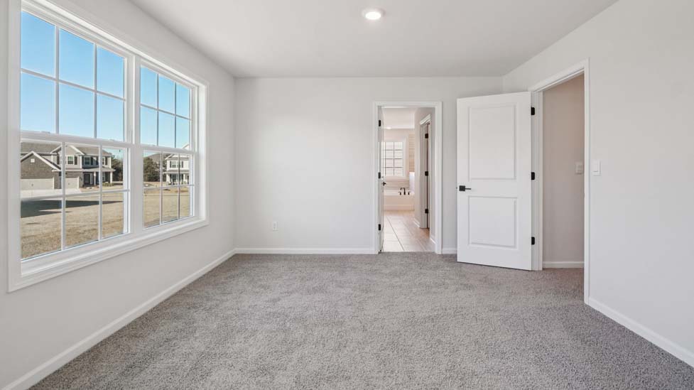 Carpeted bedroom with small window