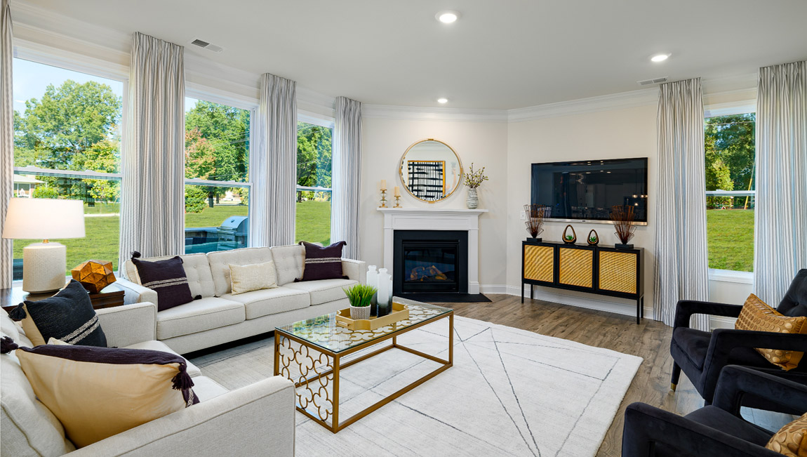 Open concept family room with wood floors, 3 large windows, and fireplace