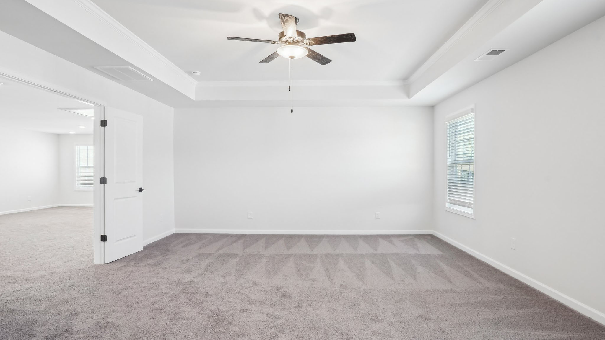 Carpeted bedroom with ceiling fan and small window