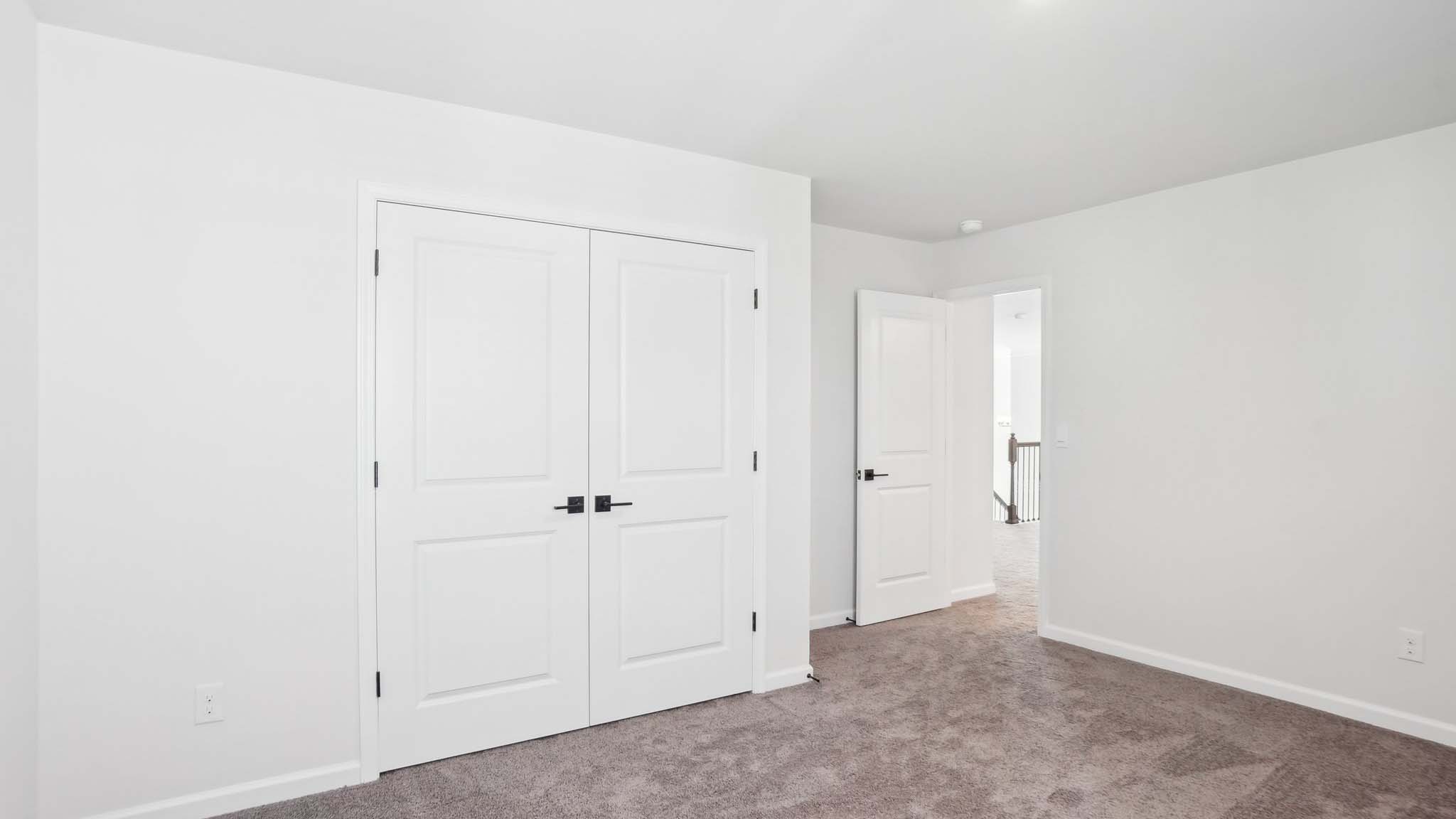 Carpeted bedroom with ceiling fan and small window