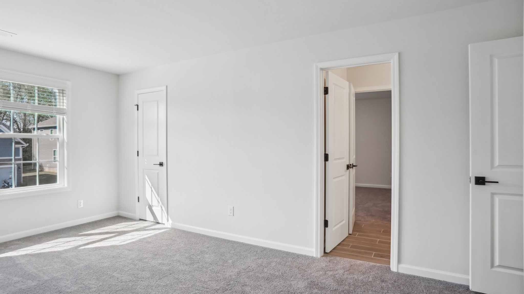Carpeted bedroom with ceiling fan and small window