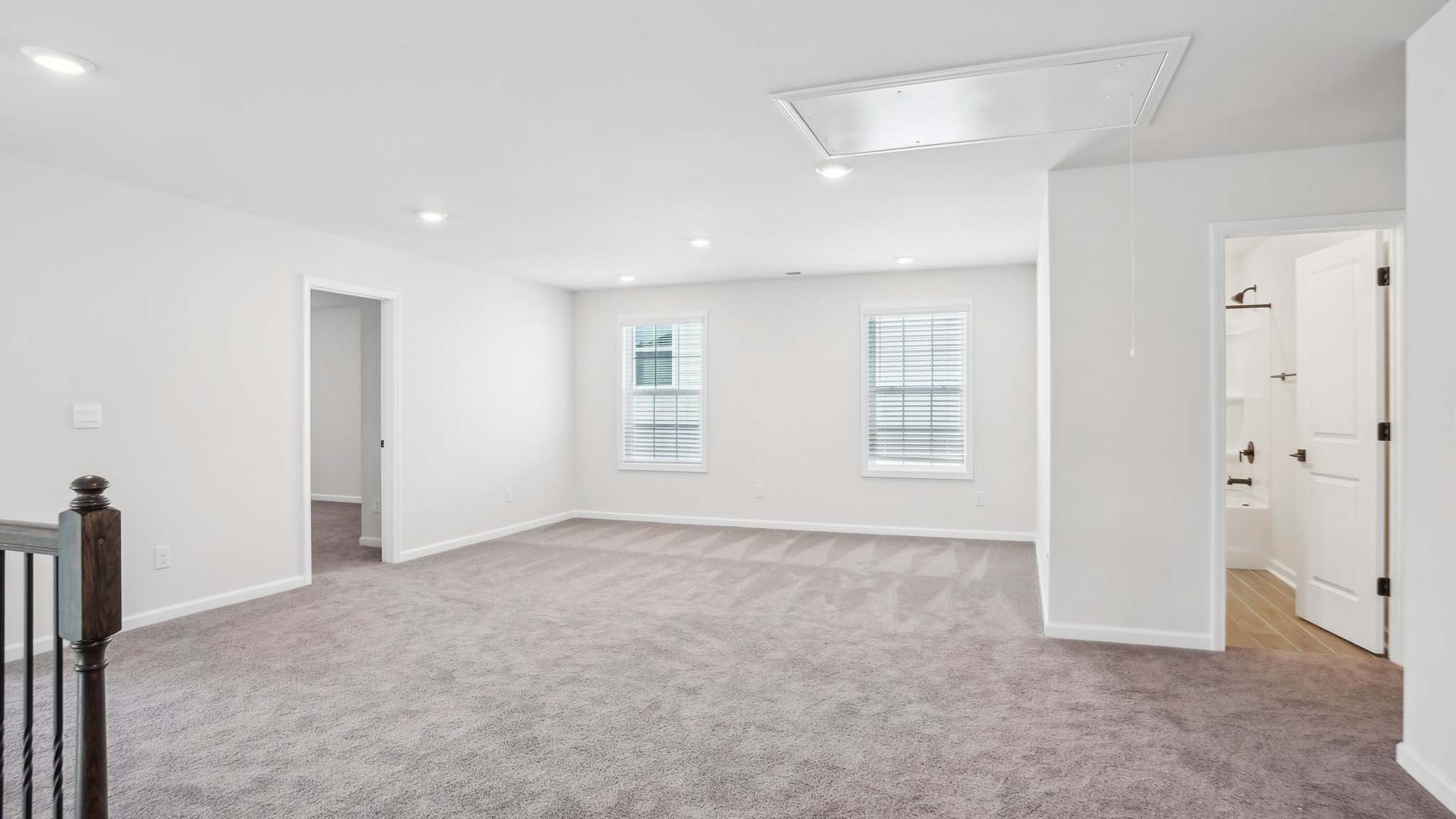 Carpeted bedroom with ceiling fan and small window