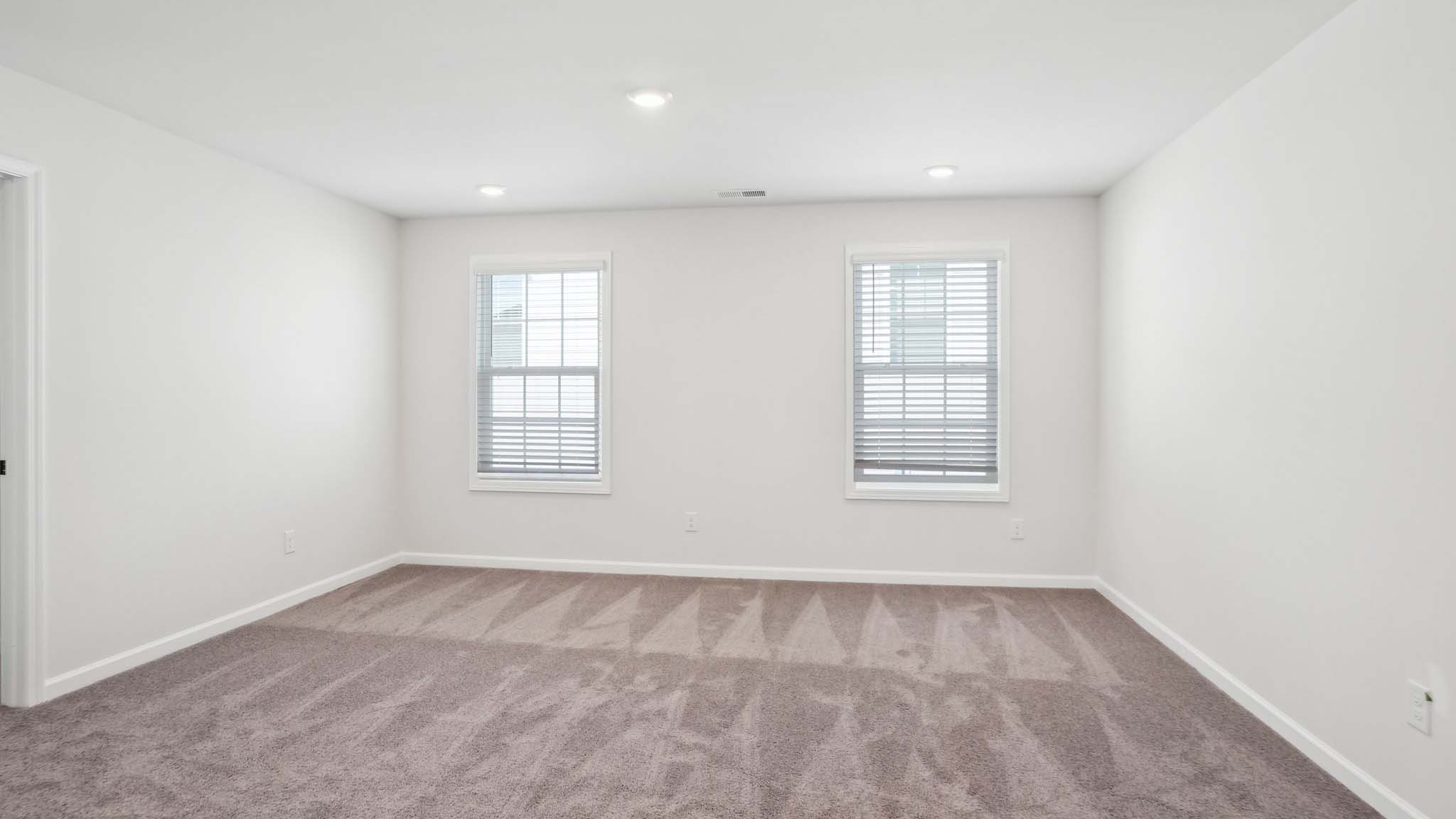 Carpeted bedroom with ceiling fan and small window