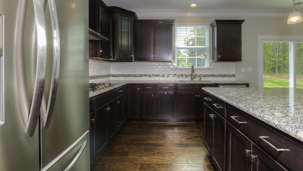 Kitchen and island with brown cabinets, and stainless steel appliances