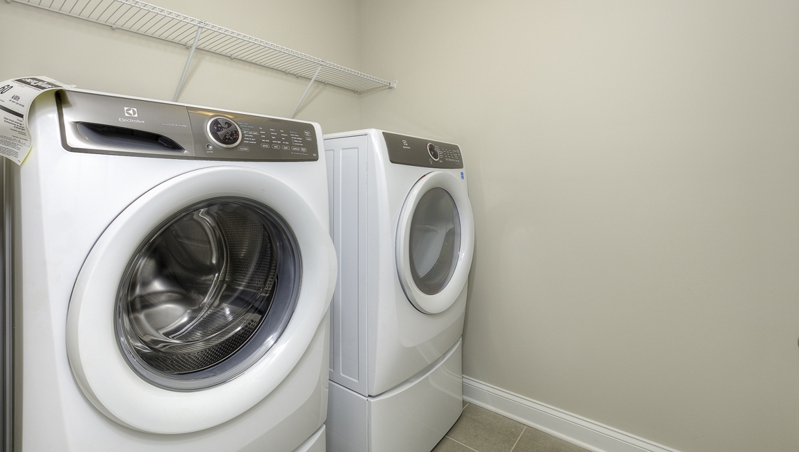 Laundry room with racks above the machines