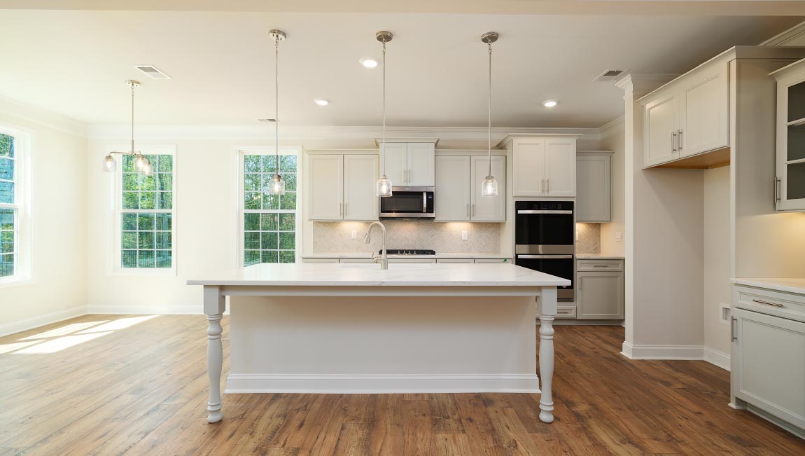 Kitchen and island with white cabinets, granite countertops, and stainless steel appliances