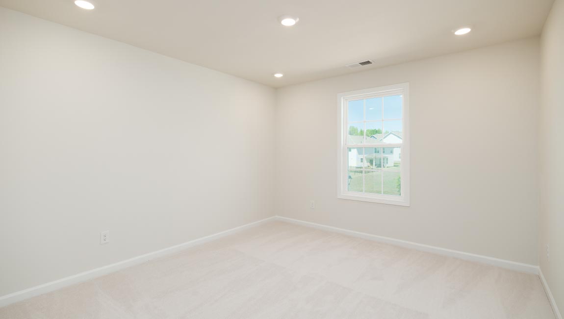 Carpeted bedroom with small window