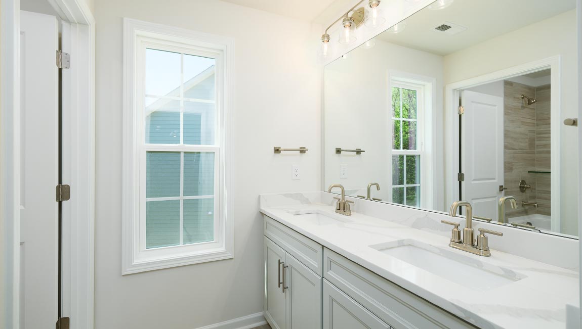 Primary bathroom with double sink vanity, large bathtub and standing glass door shower