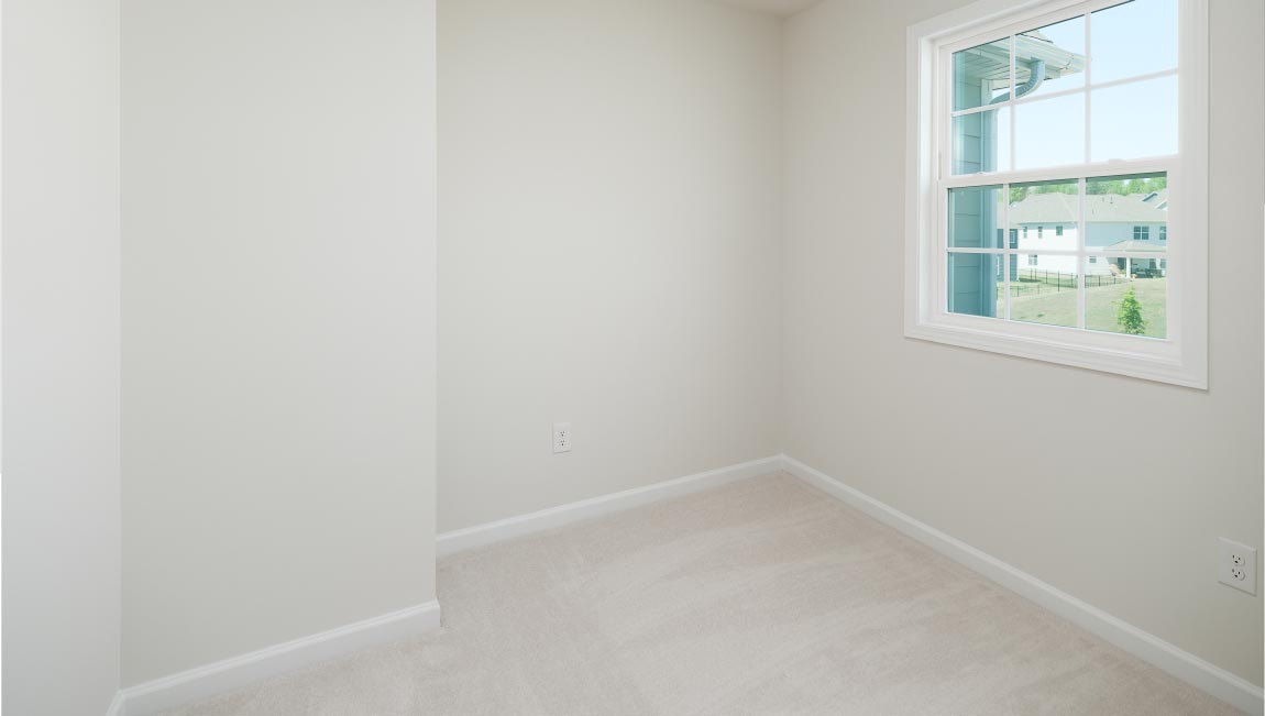 Carpeted bedroom with small window