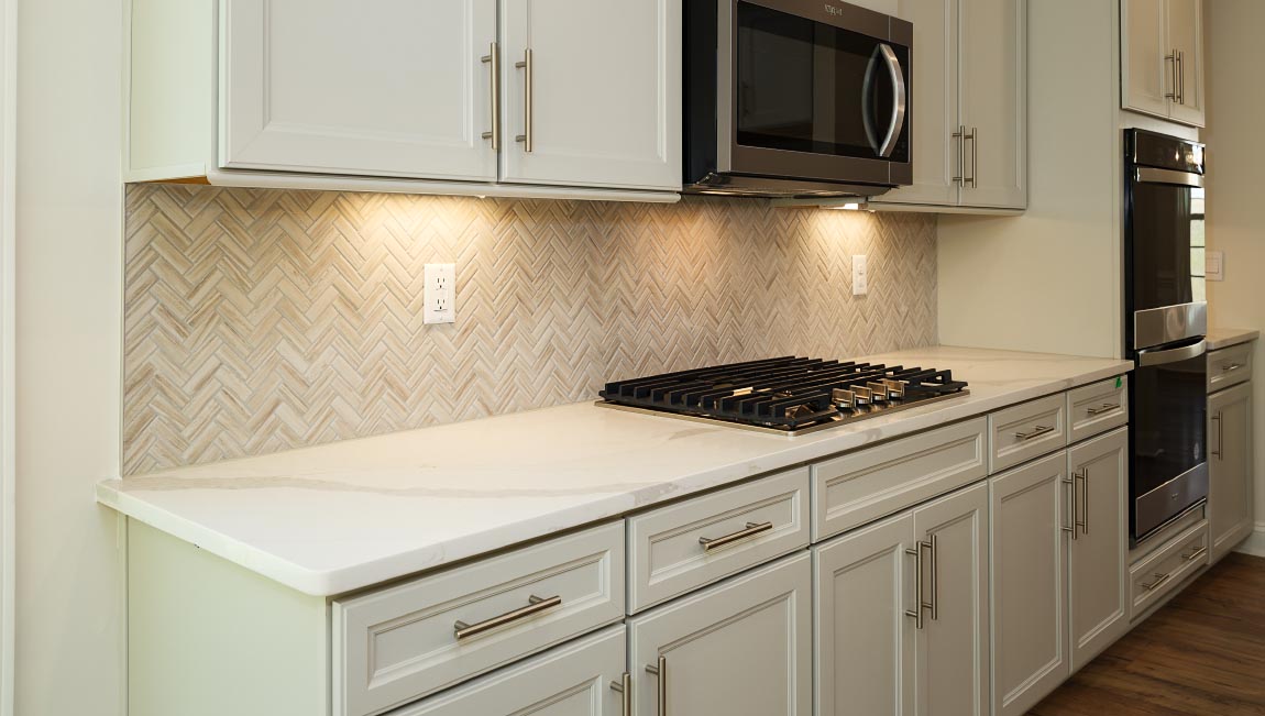 Kitchen and island with white cabinets, granite countertops, and stainless steel appliances