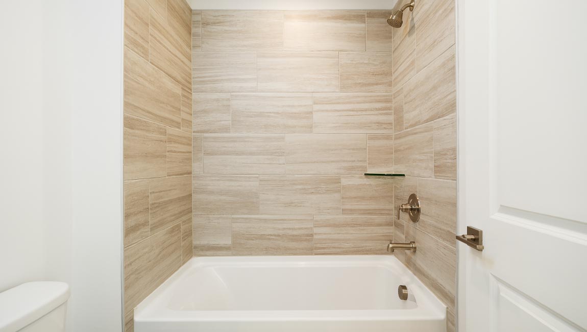 Primary bathroom with double sink vanity, large bathtub and standing glass door shower