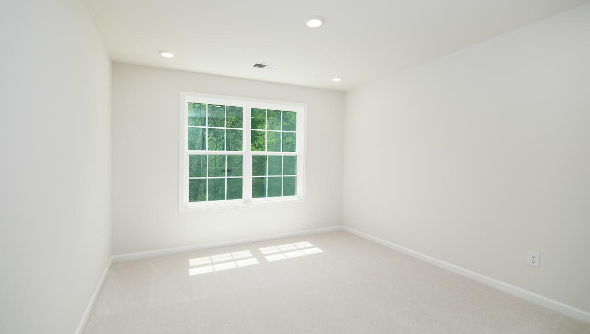Carpeted bedroom with small window