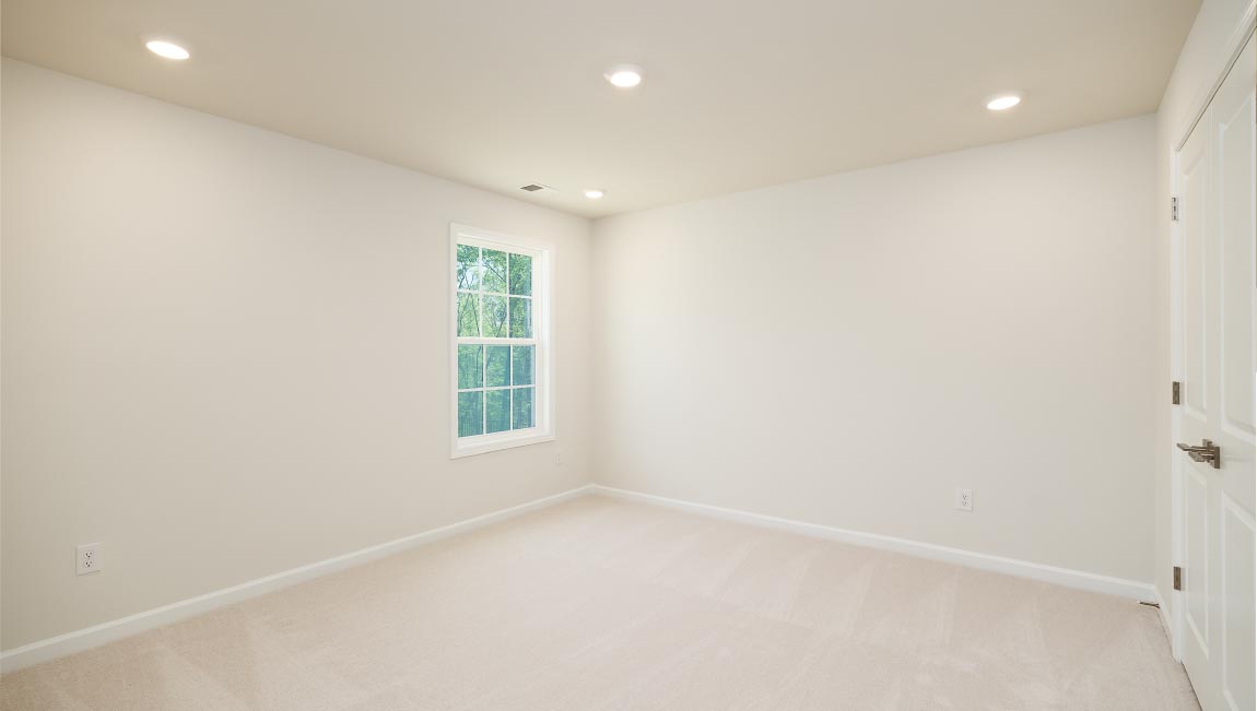 Carpeted bedroom with small window