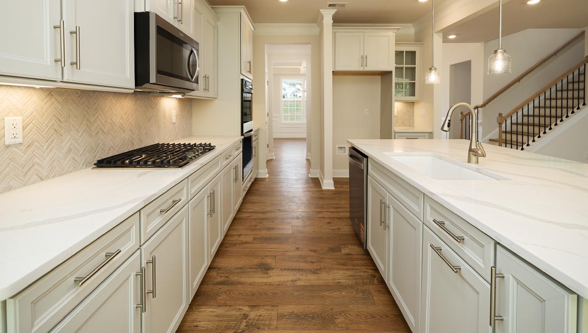Kitchen and island with white cabinets, granite countertops, and stainless steel appliances