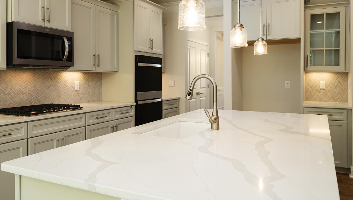 Kitchen and island with white cabinets, granite countertops, and stainless steel appliances