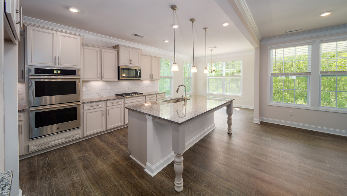 Kitchen and island with white cabinets, granite countertops, and stainless steel appliances
