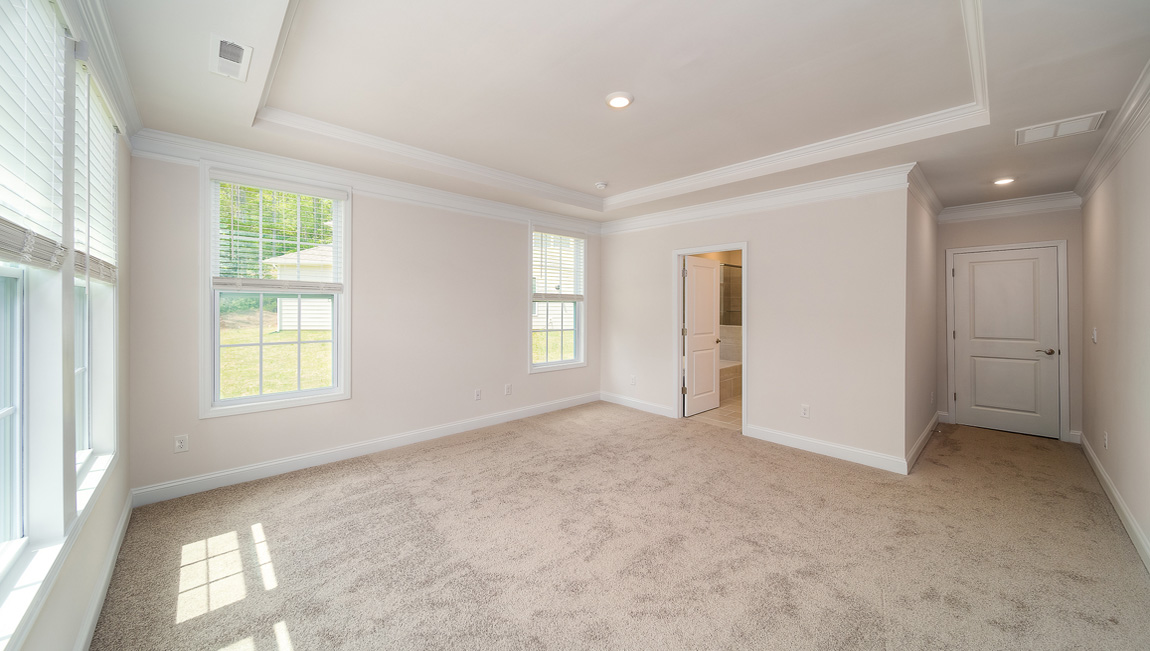 Primary bedroom with carpet and large windows