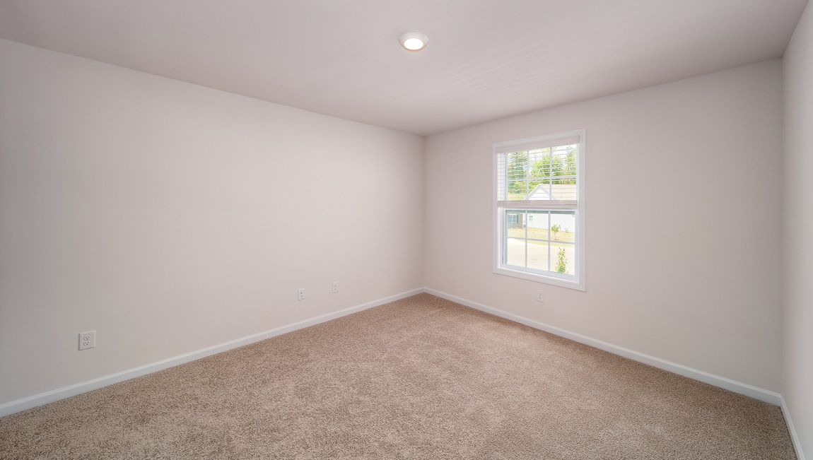 Carpeted bedroom with small window