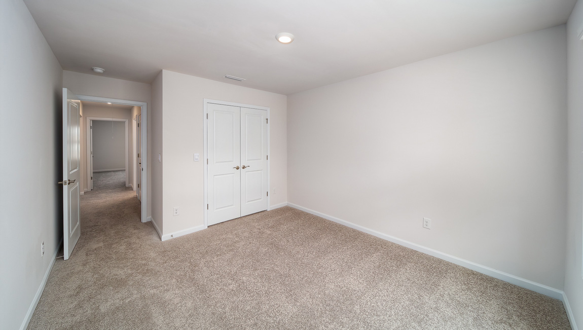 Carpeted bedroom, view of entryway