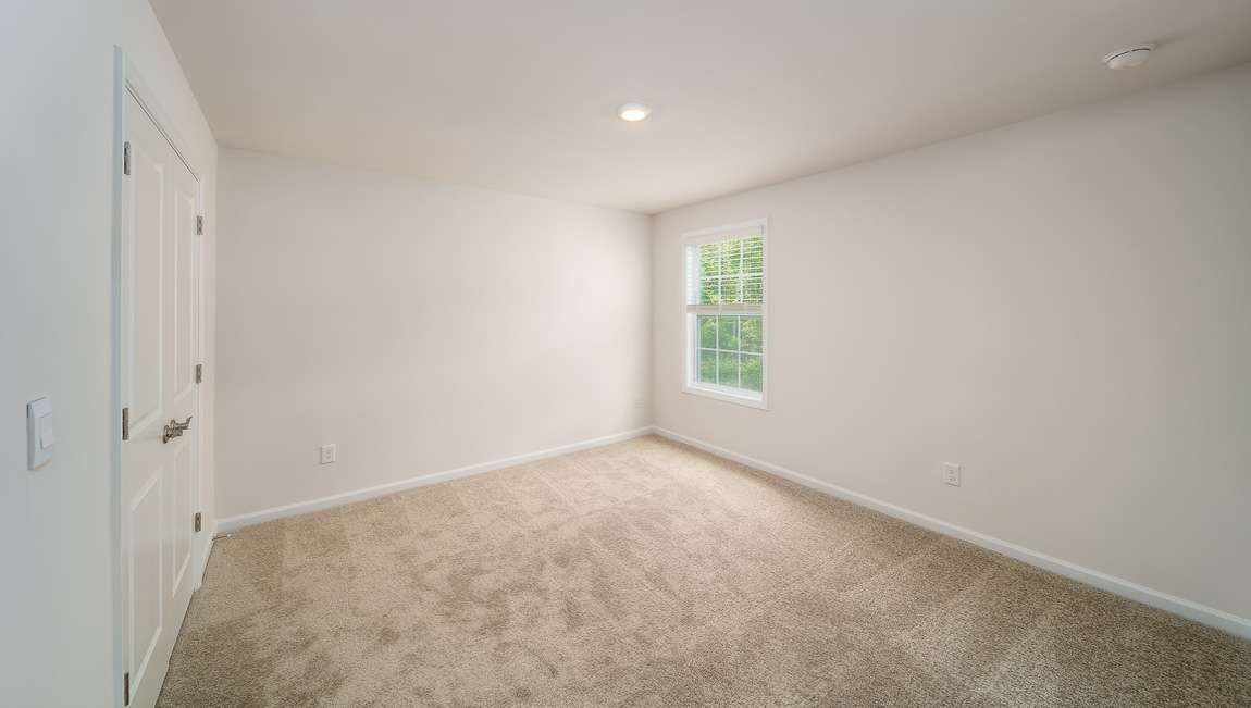 Carpeted bedroom with small window