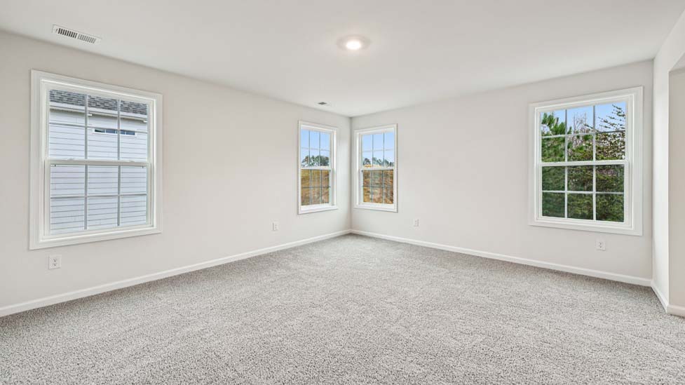 Primary bedroom, carpeted, with three windows