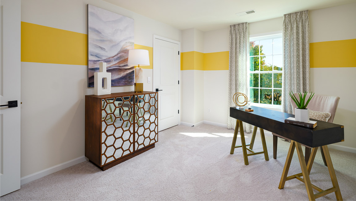 Carpeted bedroom with medium window, being used as an office
