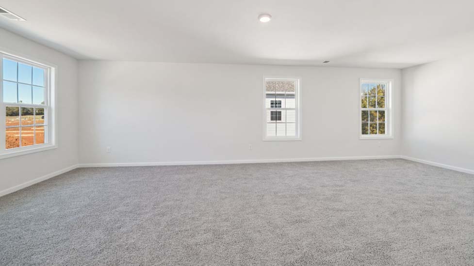 Primary carpeted bedroom with large windows