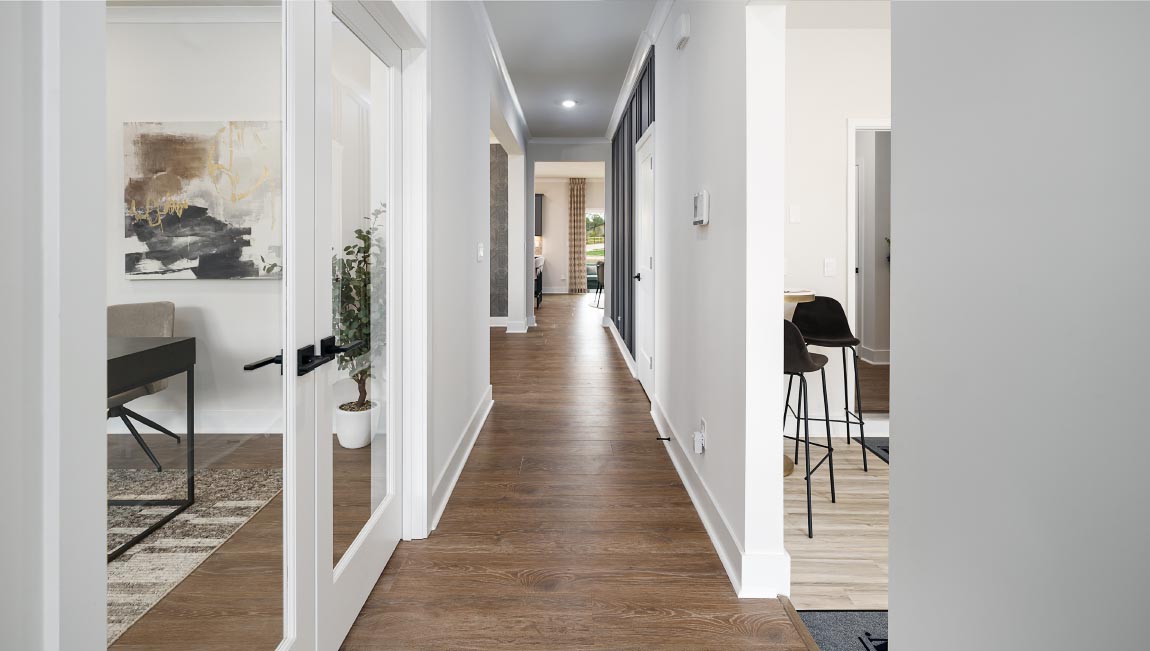 Welcoming foyer with wood floors, view of front door, and edge of dining room