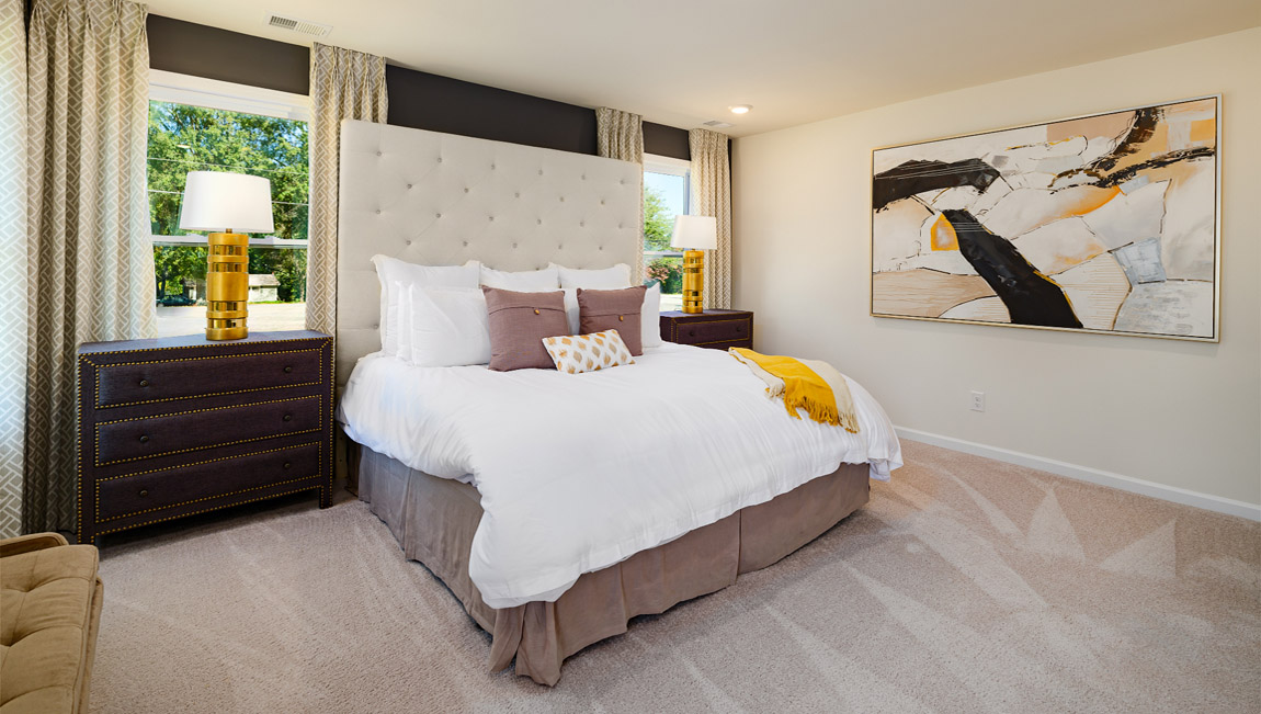 Primary carpeted bedroom with windows