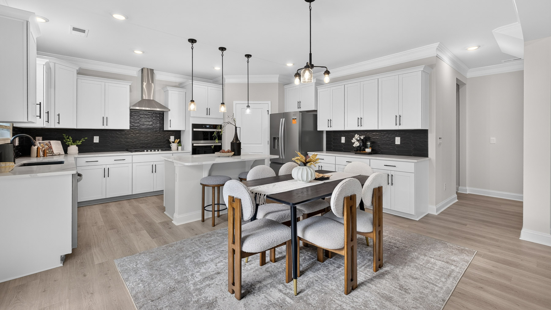 Kitchen and island with white cabinets and stainless steel appliances