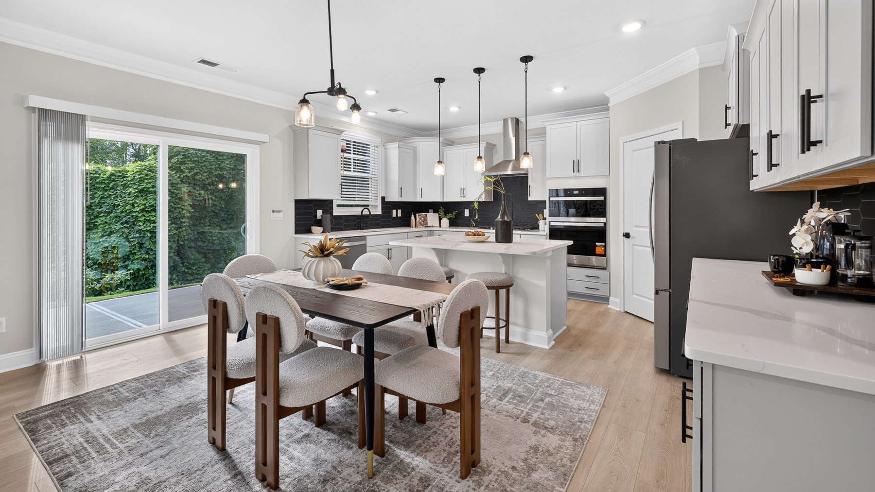 Kitchen and island with white cabinets and stainless steel appliances