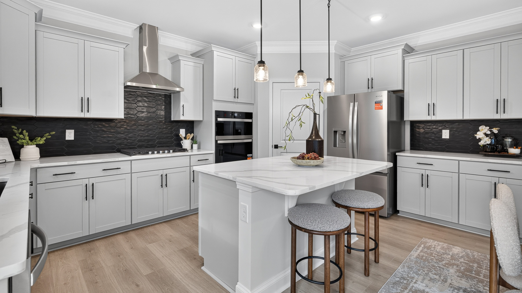Kitchen and island with white cabinets and stainless steel appliances