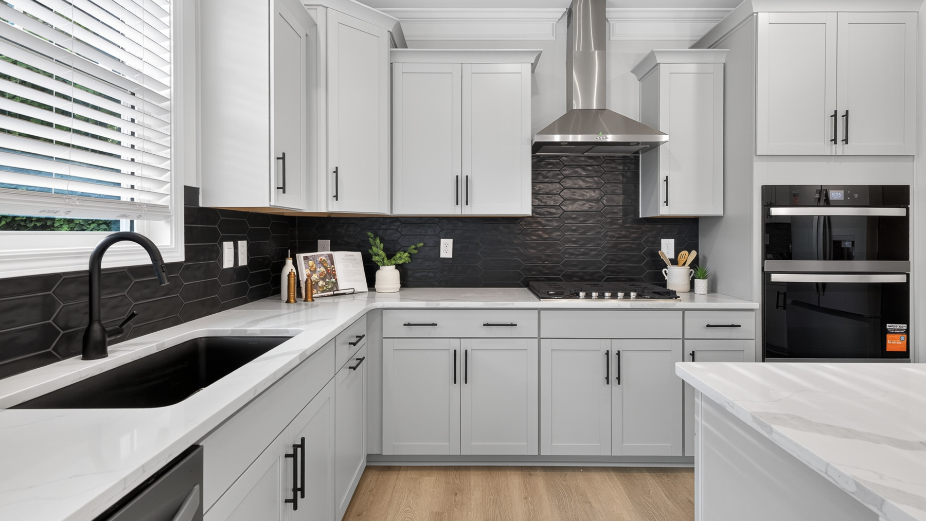 Kitchen and island with white cabinets and stainless steel appliances