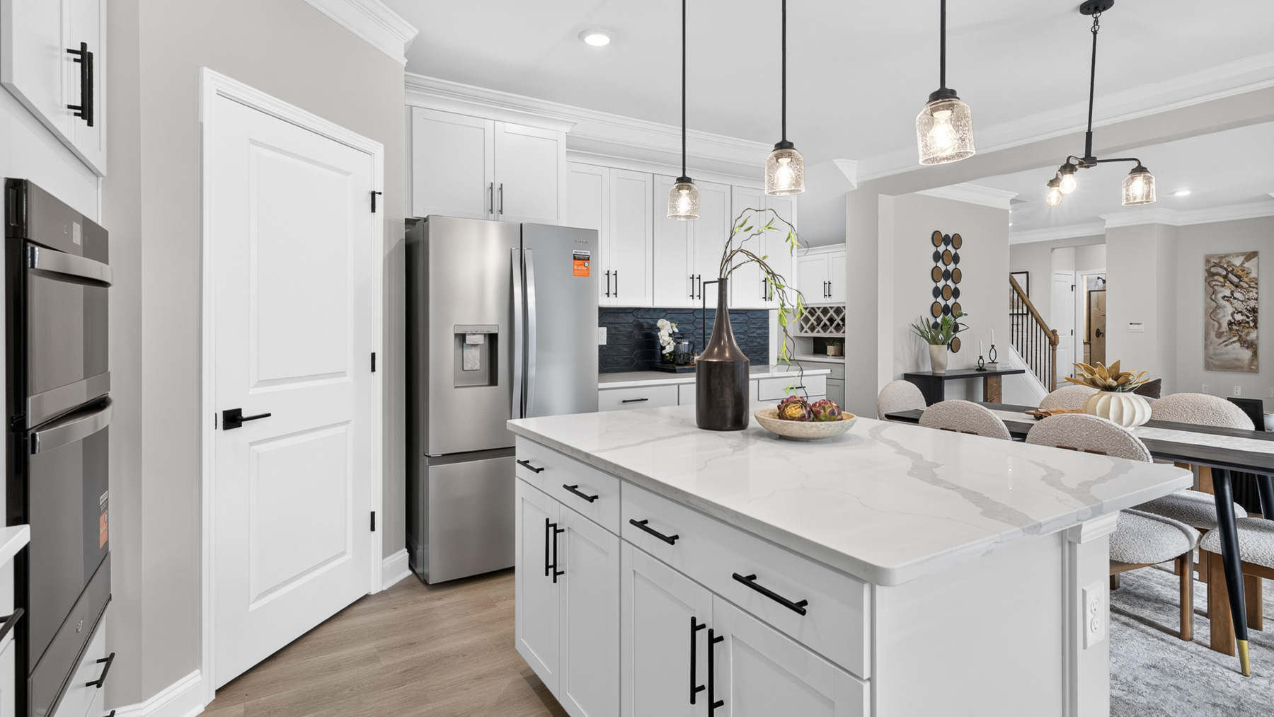 Kitchen and island with white cabinets and stainless steel appliances