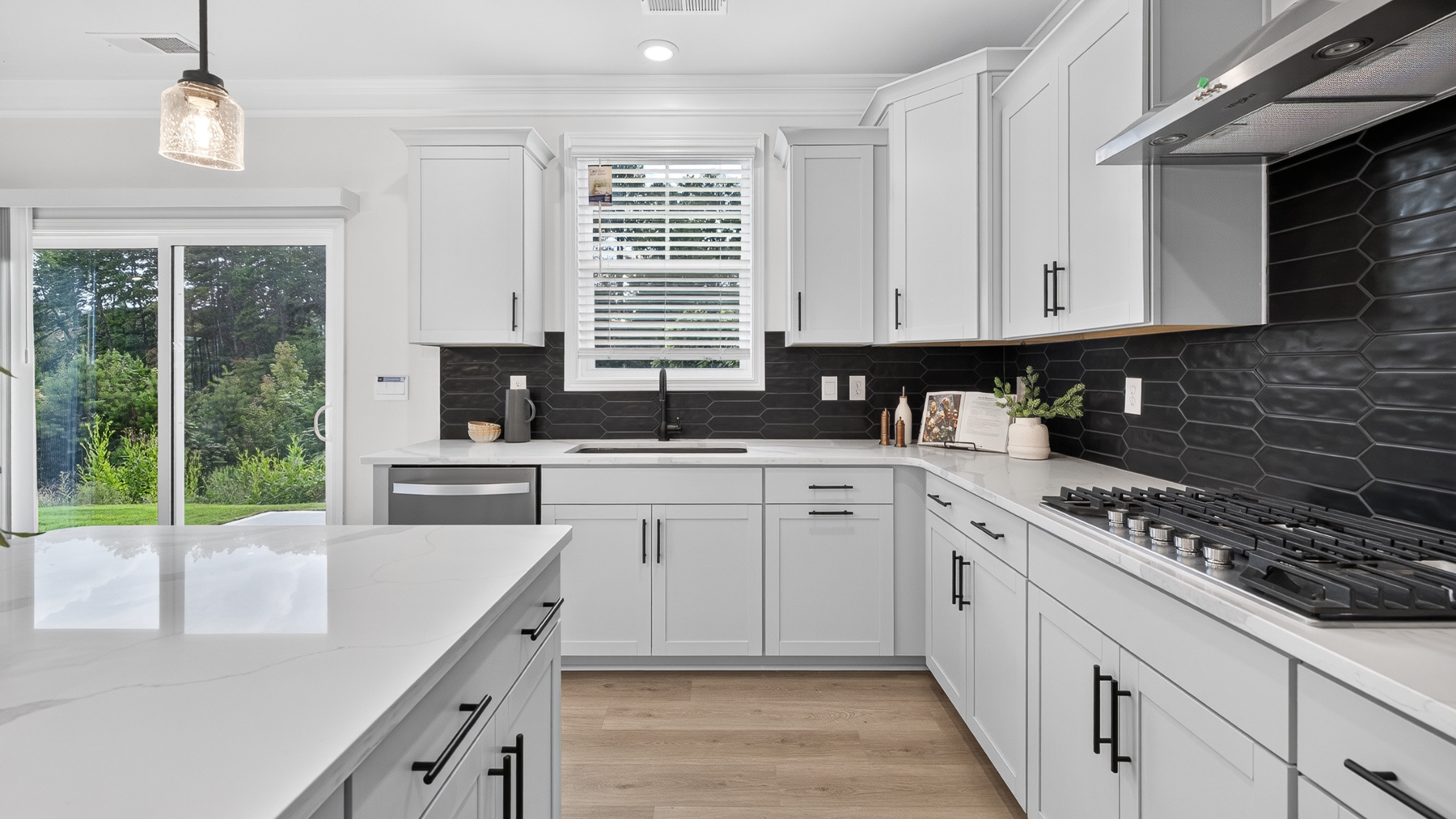 Kitchen and island with white cabinets and stainless steel appliances