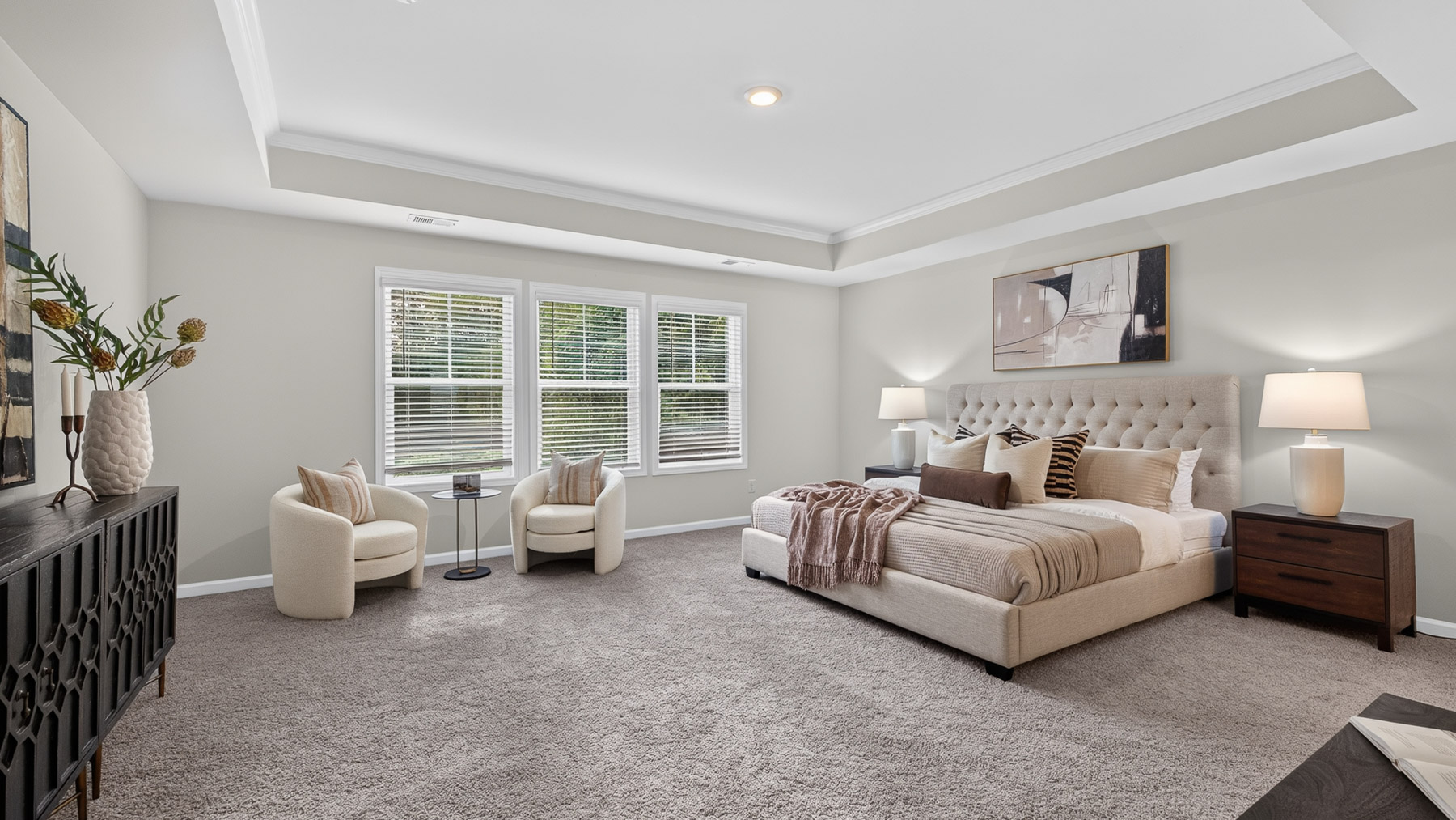 Primary bedroom with carpet, large windows, and seating area