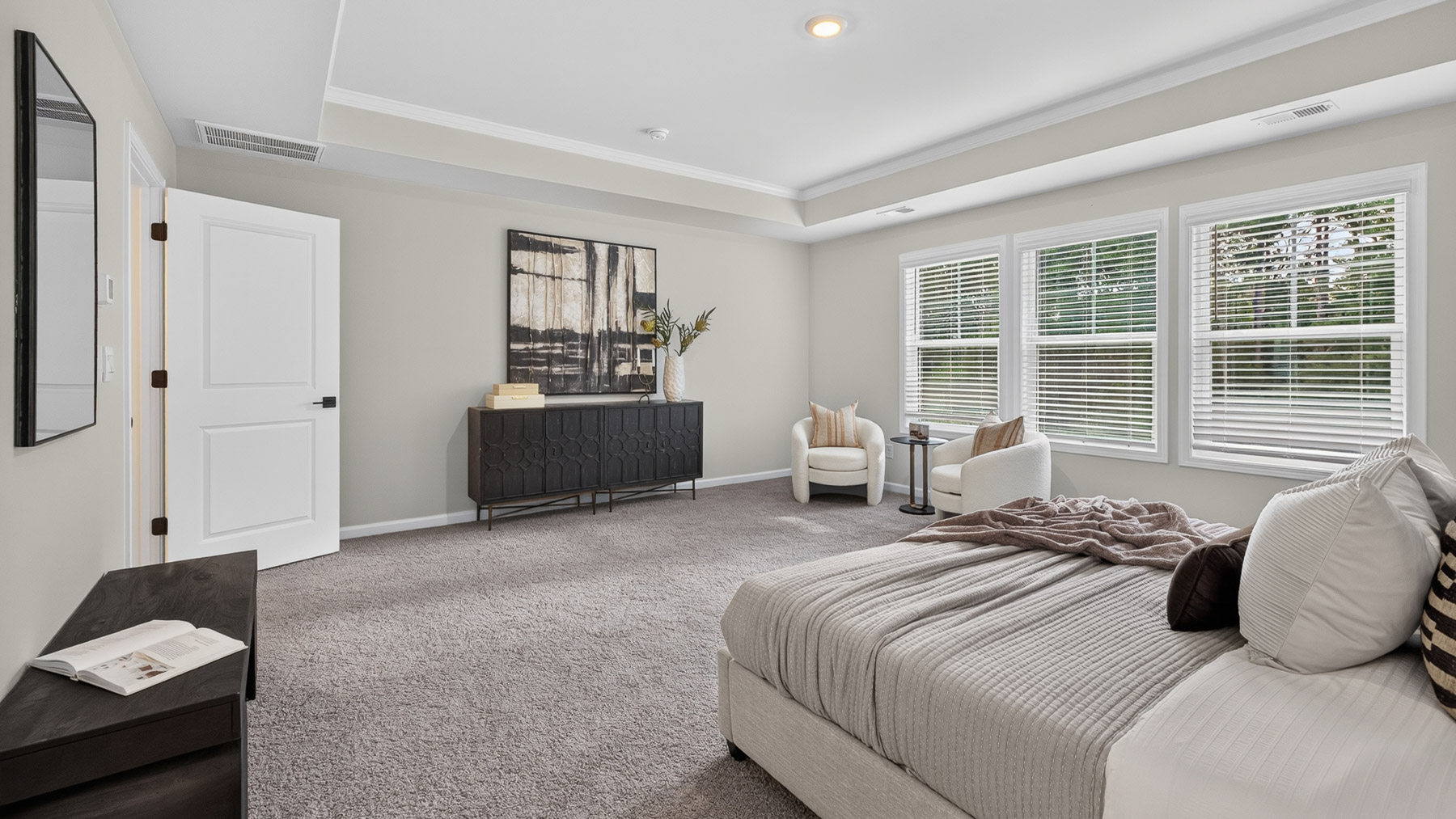 Primary bedroom with carpet, large windows, and seating area