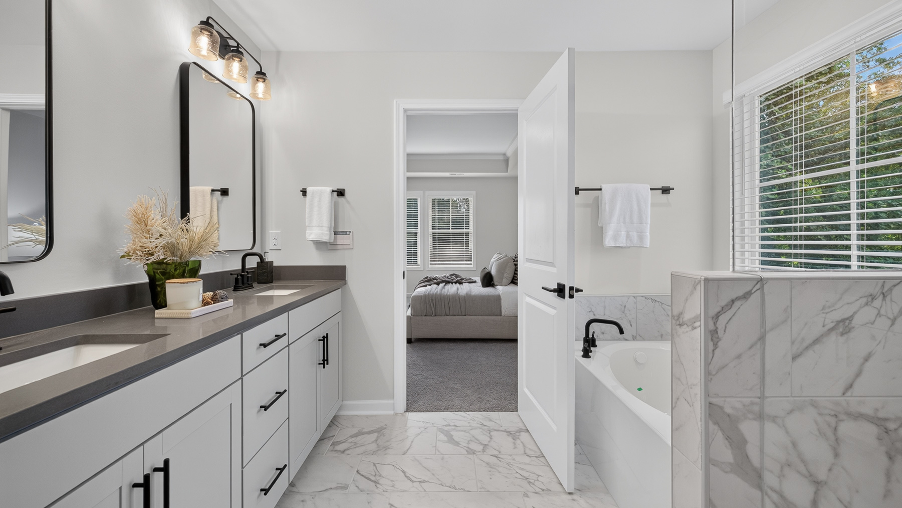 Primary bathroom with white cabinets, large bathtub ad shower