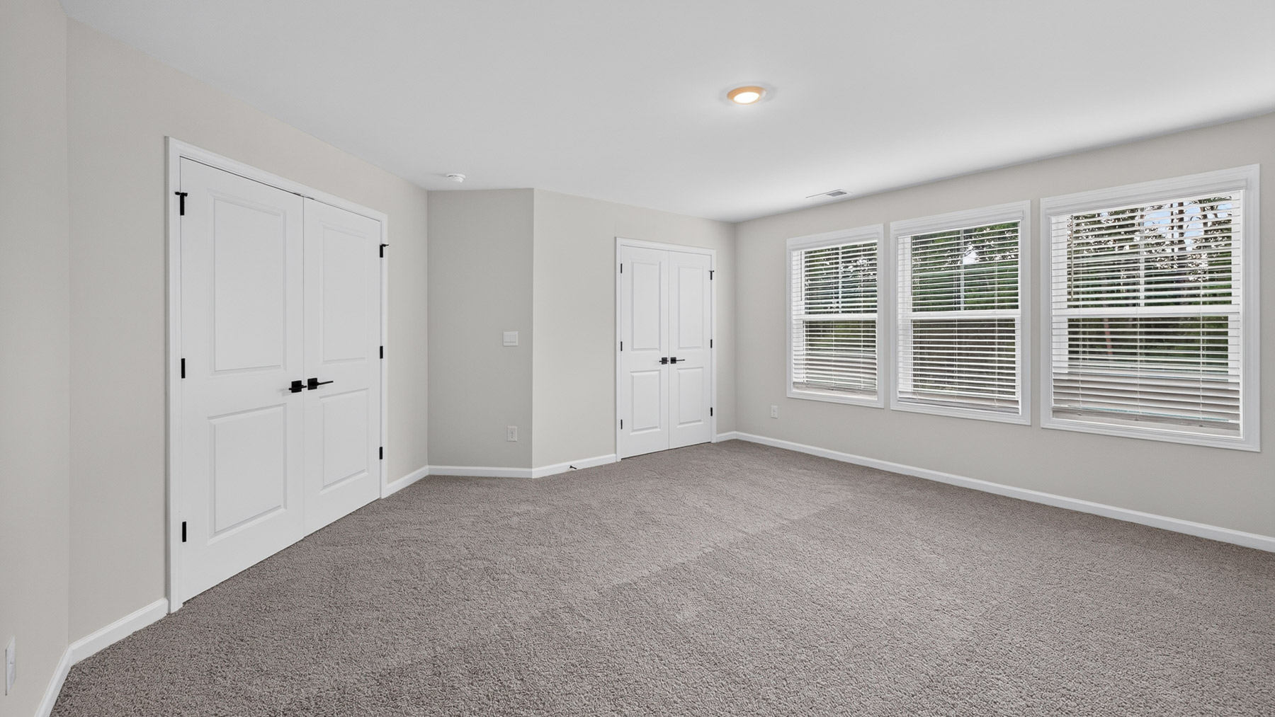 Carpeted bedroom with windows