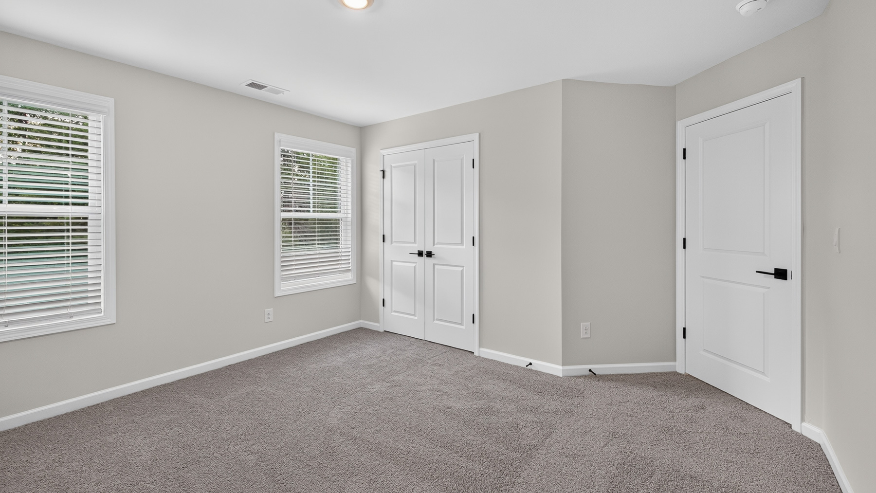 Carpeted bedroom with windows