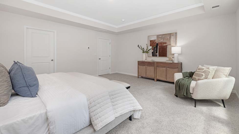 Primary bedroom with carpet, large windows, and seating area