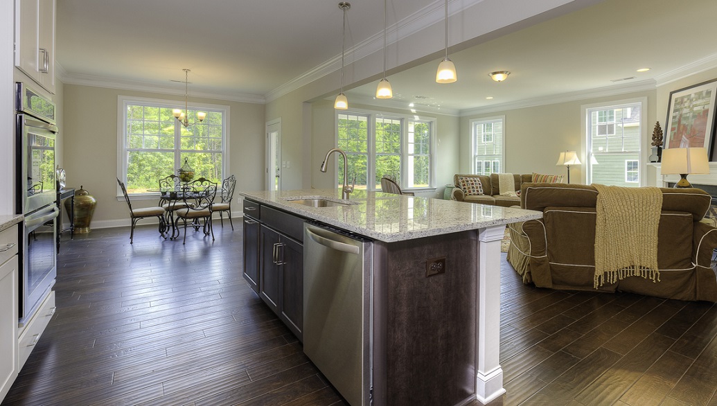 Kitchen and island with wood floors, white cabinets, and stainless steel appliances