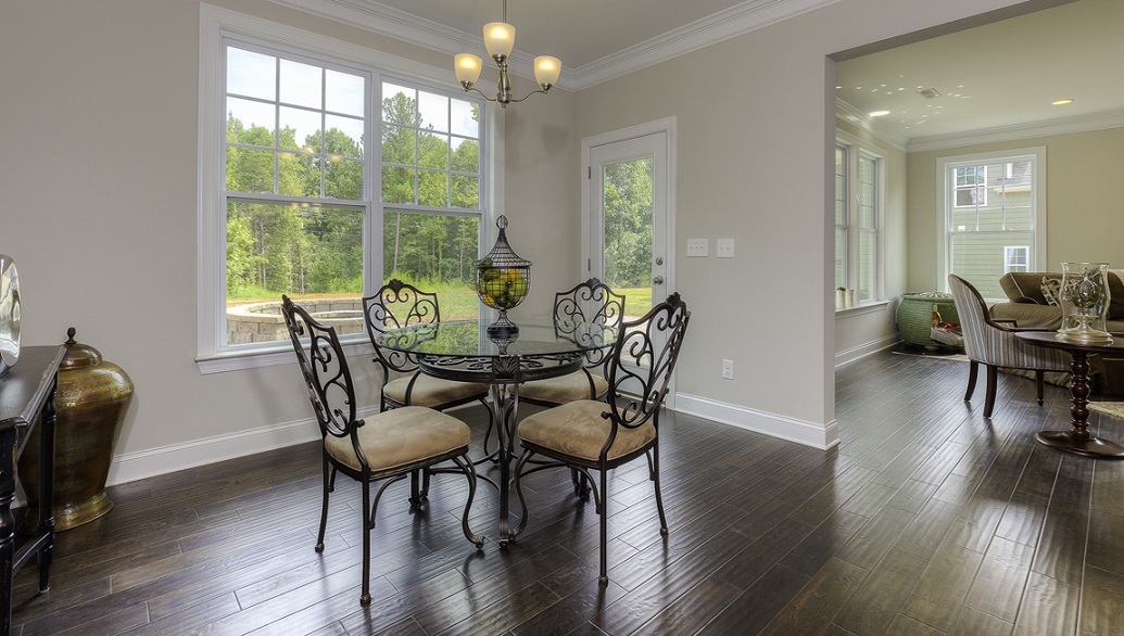 Breakfast area beside kitchen with wood floors, large window and back door